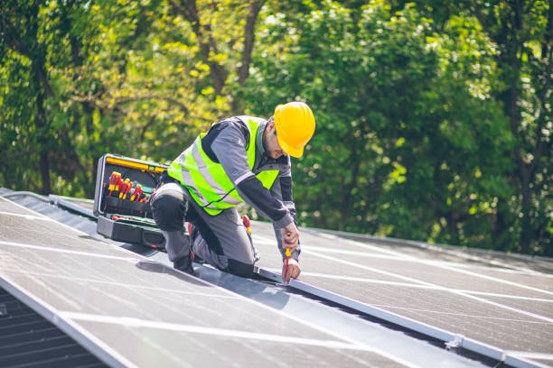 a worker is using tools to install solar panels